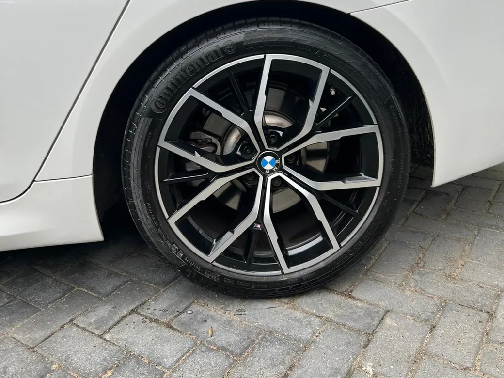 A white BMW 5 Series with refurbished two tone alloys