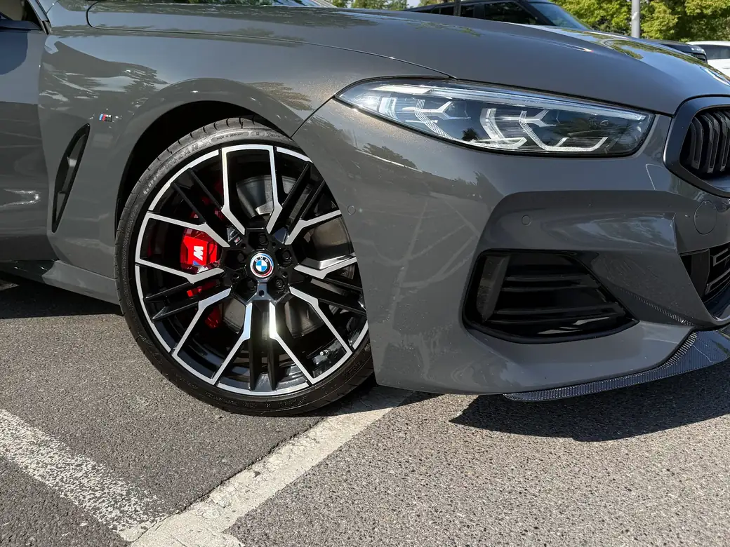 A BMW 8 Series with gloss black alloys and red brake callipers